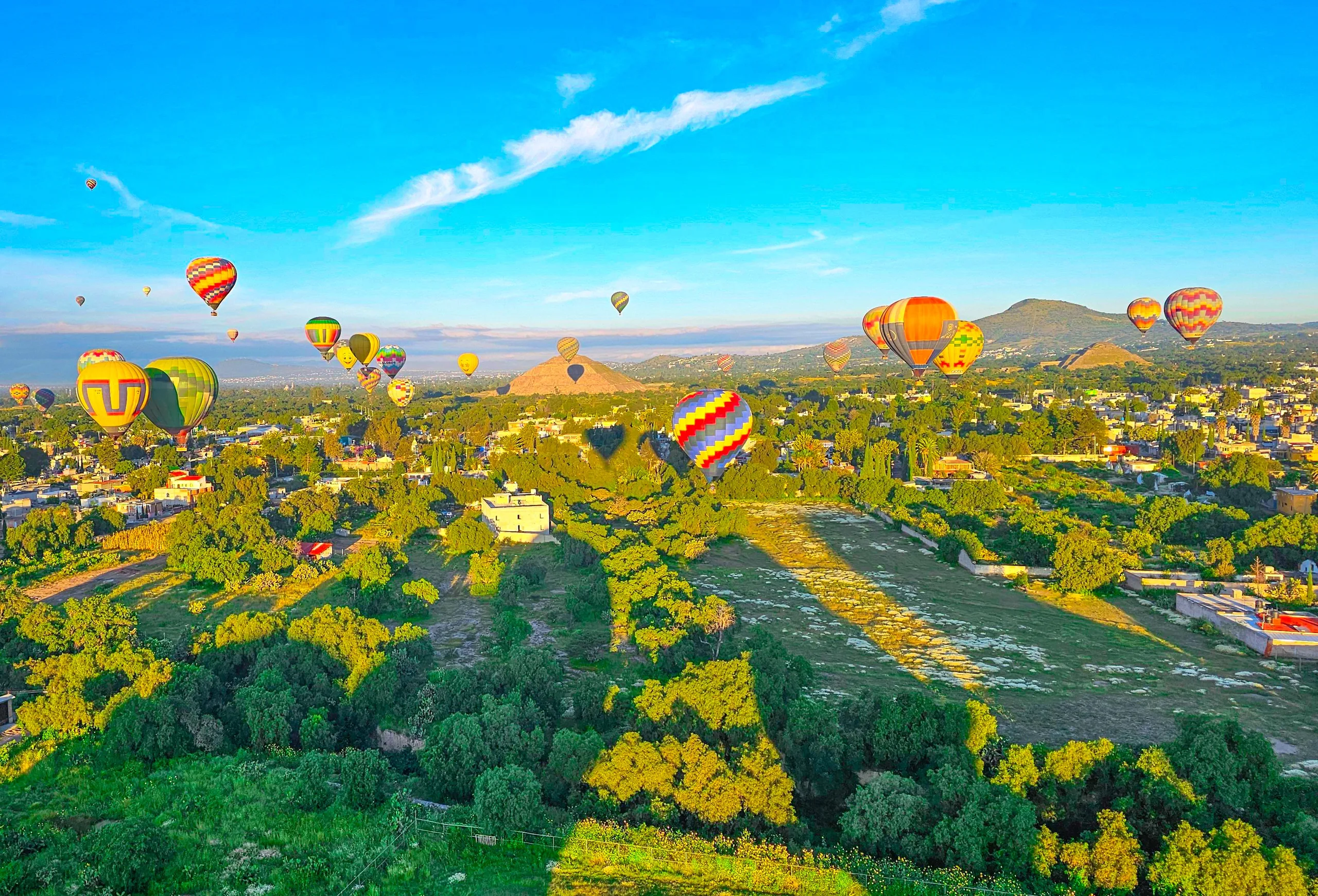Vista aérea de muchos globos sobre Teotihuacán con las pirámides a lo lejos